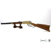 Denix Winchester 1873 replika rifle i gull på stativ, sett fra siden